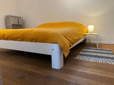 a bed with a yellow blanket on it in a room at Richard XIII in Antwerp