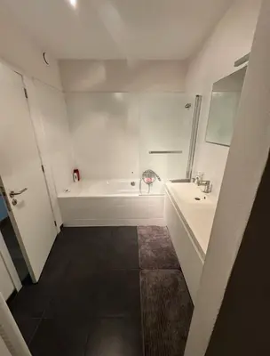 a white bathroom with a tub and a sink at Le Refuge Historique WIFI - Parking - Confort in Brussels