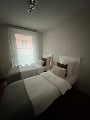 two beds in a room with a window at Le Refuge Historique WIFI - Parking - Confort in Brussels