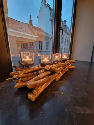 a group of candles on a table with logs at Cozy Room, Big City Adventures III in Ghent