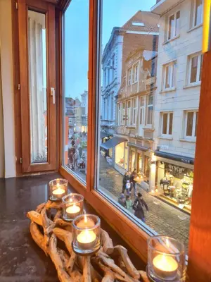 a group of candles on a table in front of a window at Cozy Room in the Heart of Ghent I in Ghent