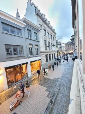 a group of people walking down a street with buildings at Cozy Room in the Heart of Ghent I in Ghent