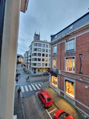 a red car is parked on a city street at Charming Room in Ghent center II in Ghent