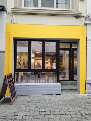 a yellow and black store window with chairs in it at Charming Room in Ghent center II in Ghent