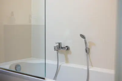 a shower with a glass door next to a bath tub at Machelen in Machelen