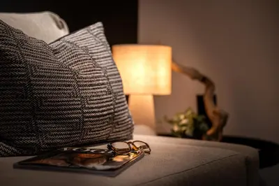 a tray with a pair of glasses on a bed with a lamp at The Studio in Antwerp