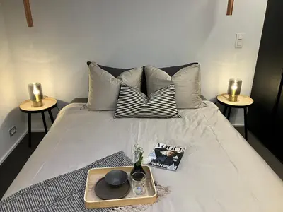 a bed with a tray with a book and a magazine at The Studio in Antwerp