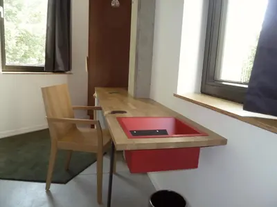 a kitchen with a wooden table with a red sink at Hôtel Belvue in Brussels