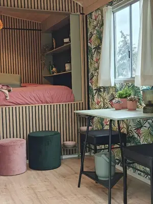 a bedroom with a bed and a table and chairs at Trees in Assenede