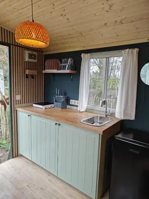 a kitchen with a sink and a window at Trees in Assenede