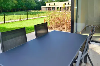 a blue table and chairs with a view of a field at Bielebale Vakantiehuisjes in Brasschaat
