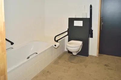 a bathroom with a toilet and a bath tub at Bielebale Vakantiehuisjes in Brasschaat