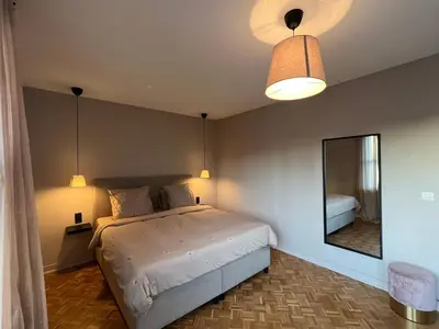 a bedroom with a large bed and a mirror at Appartement Brussels Expo in Strombeek-Bever