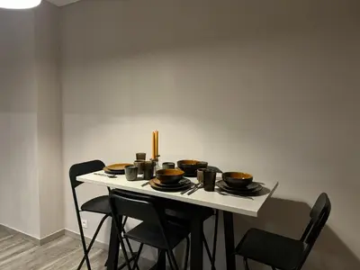 a table with chairs and bowls and plates on it at Appartement Brussels Expo in Strombeek-Bever