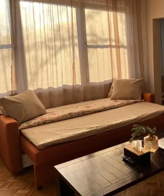 a large couch sitting in front of a window at Appartement Brussels Expo in Strombeek-Bever