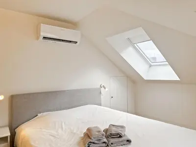 a bedroom with a bed with towels on it at Charming Ixelles Apartment Retreat in the Heart of Brussels in Brussels
