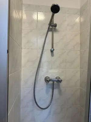 a shower with a shower head in a bathroom at Charming Uccle Apartment with City Views in Brussels