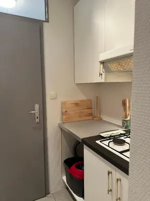 a kitchen with white cabinets and a stove top oven at Charming Uccle Apartment with City Views in Brussels