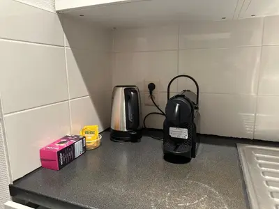 a kitchen counter with a coffee maker and a toaster at Charming Uccle Apartment with City Views in Brussels