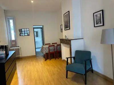 a living room with a chair and a table at Charming Uccle Apartment with City Views in Brussels