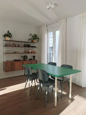 a dining room with a green table and chairs at Living Gent in Ghent