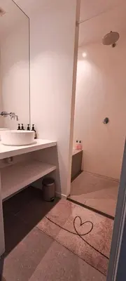 a bathroom with a sink and a shower with a heart on the floor at Living Gent in Ghent