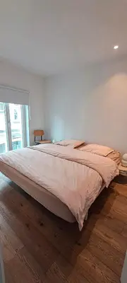 a large bed in a bedroom with a wooden floor at Living Gent in Ghent