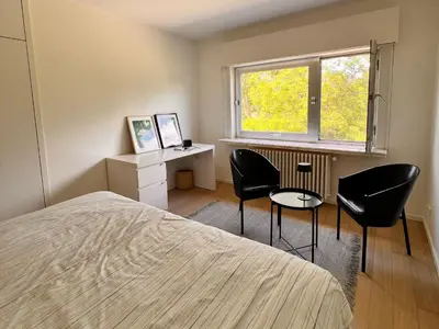 a bedroom with a bed and a desk and chairs at B&B near Ghent in Merelbeke