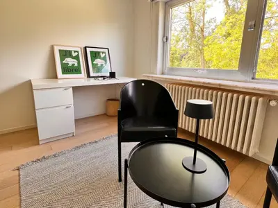 a black chair in a room with a desk and a window at B&B near Ghent in Merelbeke