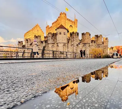 a castle with a reflection in a puddle in front of it at B&B near Ghent in Merelbeke