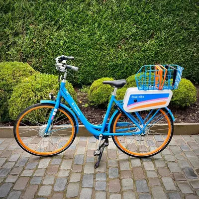 a blue bike parked on a sidewalk with a basket at B&B near Ghent in Merelbeke