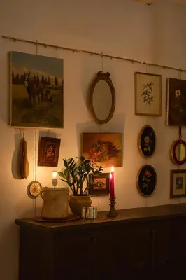 a wall filled with pictures and a candle on a table at Gent Gently apartment in center in Ghent