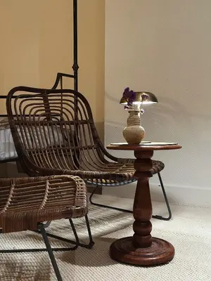 a rattan chair and a table with a lamp at Gent Gently apartment in center in Ghent