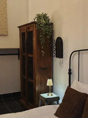 a bedroom with a wooden cabinet next to a bed at Gent Gently apartment in center in Ghent