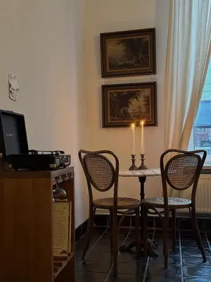 a room with a table with two chairs and a candle at Gent Gently apartment in center in Ghent