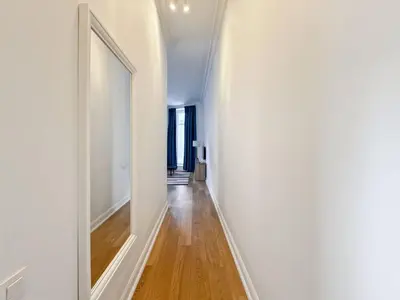 a hallway with white walls and a large mirror at self check in Ixelles Apartment Retreat in the Heart of Brussels in Brussels