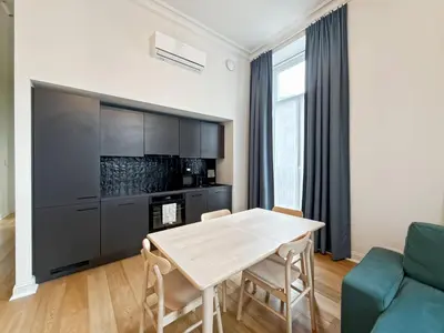 a kitchen and living room with a table and chairs at self check in Ixelles Apartment Retreat in the Heart of Brussels in Brussels