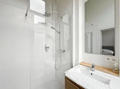 a white bathroom with a shower and a sink at self check in Ixelles Apartment Retreat in the Heart of Brussels in Brussels