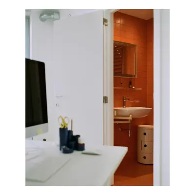 a bathroom with a sink and a desk with a computer at Garden flat in central brussels in Brussels