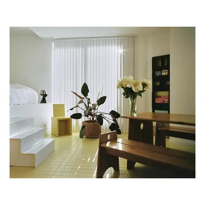 a living room with flowers and tables and a bed at Garden flat in central brussels in Brussels