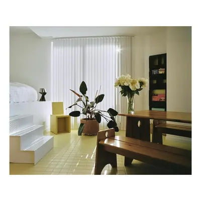 a living room with flowers and tables and a bed at Garden flat in central brussels in Brussels