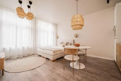 a white bedroom with a bed and a table and a table at BelGem in Antwerp