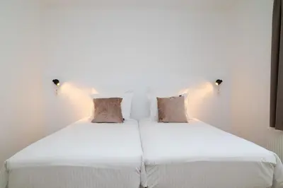 a bedroom with two beds with white sheets and pillows at SAFIR by Domani Hotels in Aalst