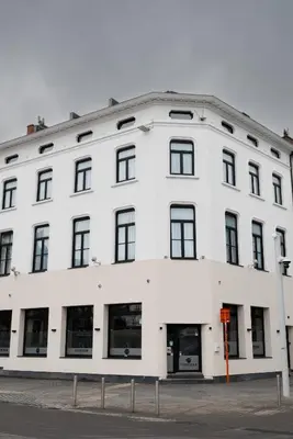 a white building with black windows on a street at SAFIR by Domani Hotels in Aalst
