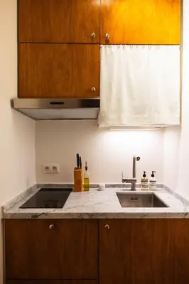 a kitchen with wooden cabinets and a sink at Studio Lido by Simone Antwerp in Antwerp