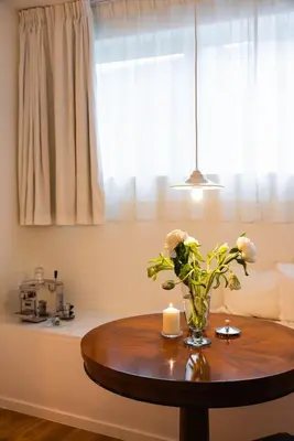 a vase of flowers on a table in a room at Studio Lido by Simone Antwerp in Antwerp
