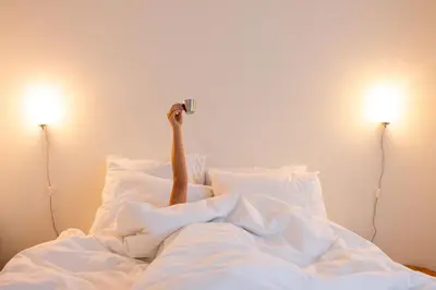 a person laying in bed taking a picture with a camera at Studio Lido by Simone Antwerp in Antwerp