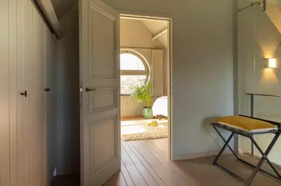 a hallway with a door and a chair and a window at Waterfront vacation home in Sint-Amands