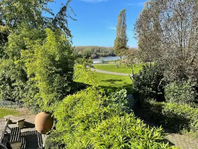 a view of a garden with trees and bushes at Waterfront vacation home in Sint-Amands