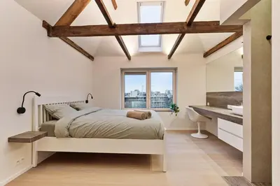 a bedroom with a bed and a sink and a window at Luxury escape in the heart of historic Mechelen in Mechelen